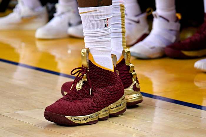 View of maroon and gold Nike LeBron shoes.